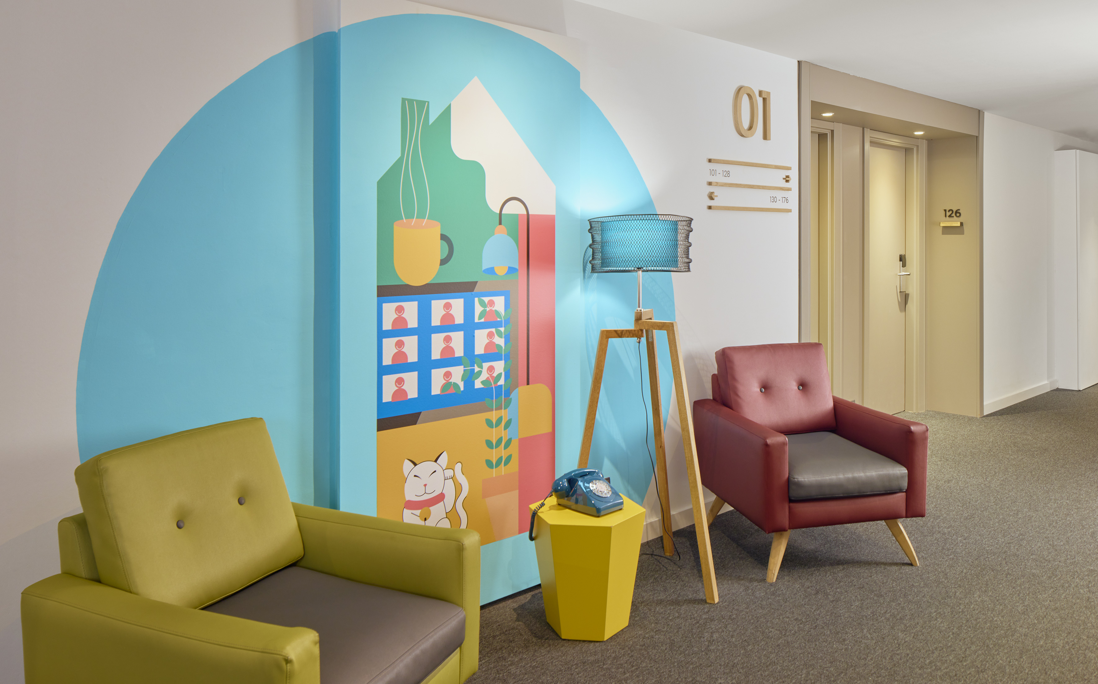 Hotel lobby with vibrant mural, armchairs, tripod lamp, and vintage phone.