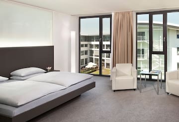 a bedroom with a bed and chairs