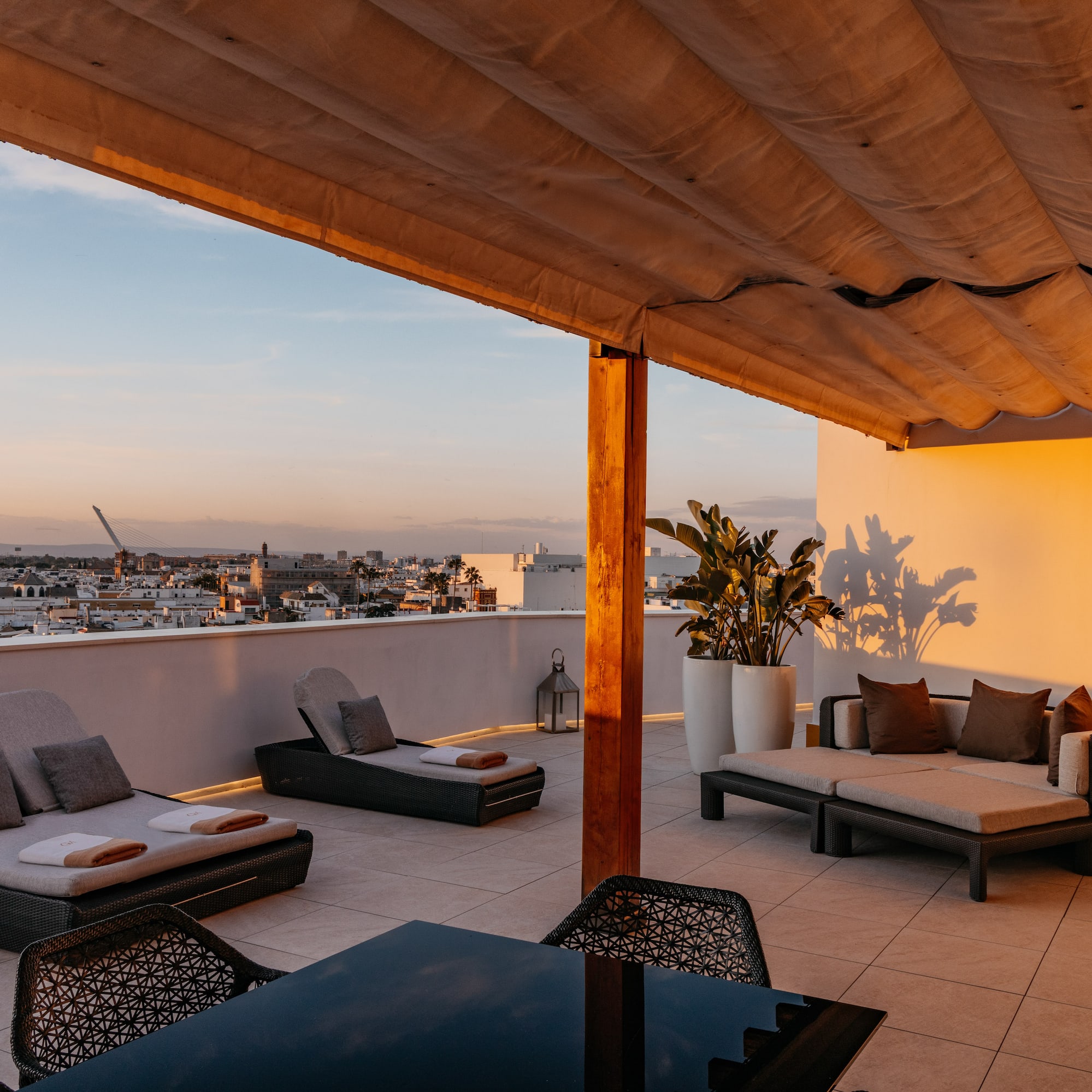 a patio with chairs and a table on a rooftop