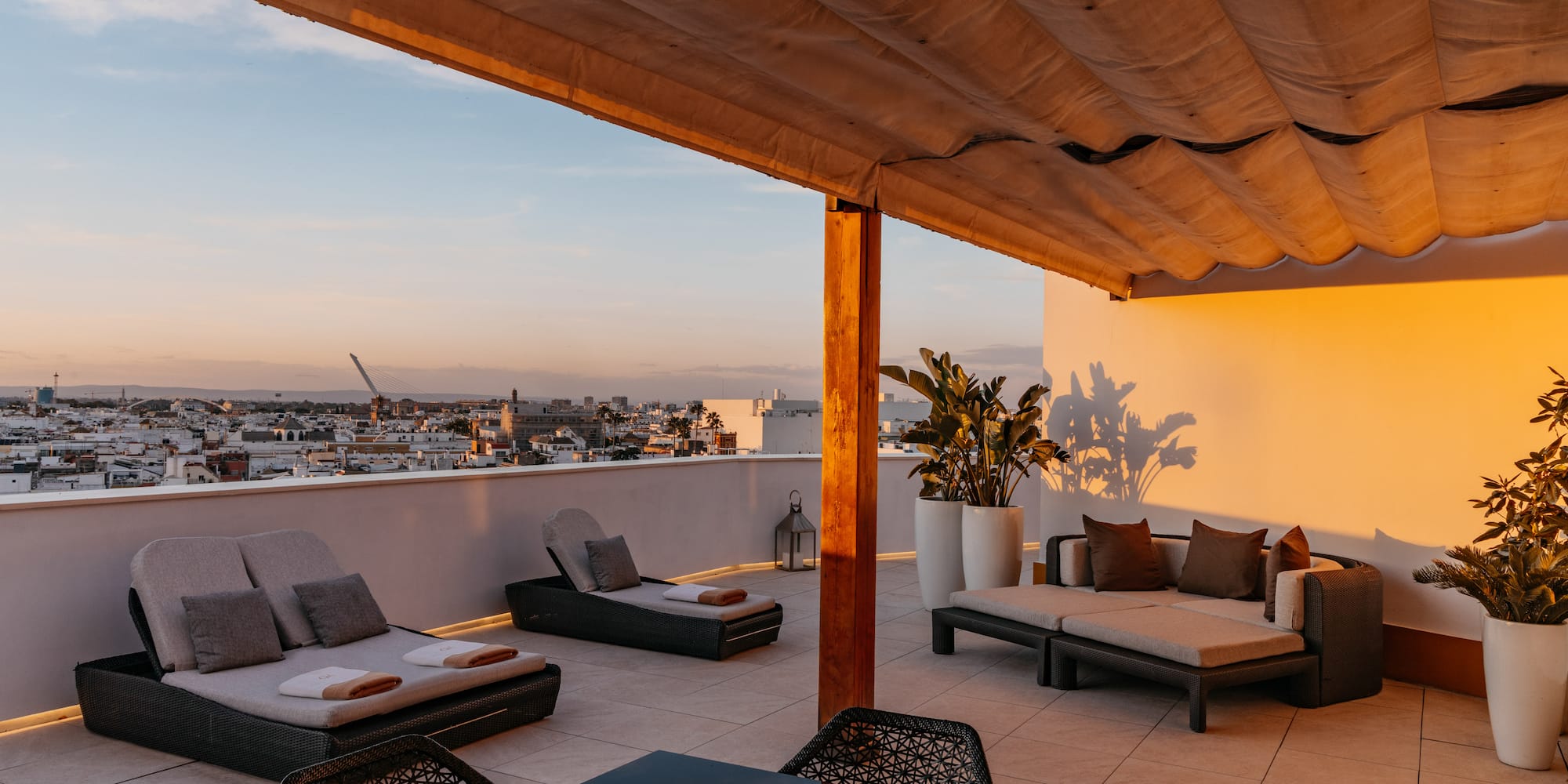 a patio with chairs and a table on a rooftop