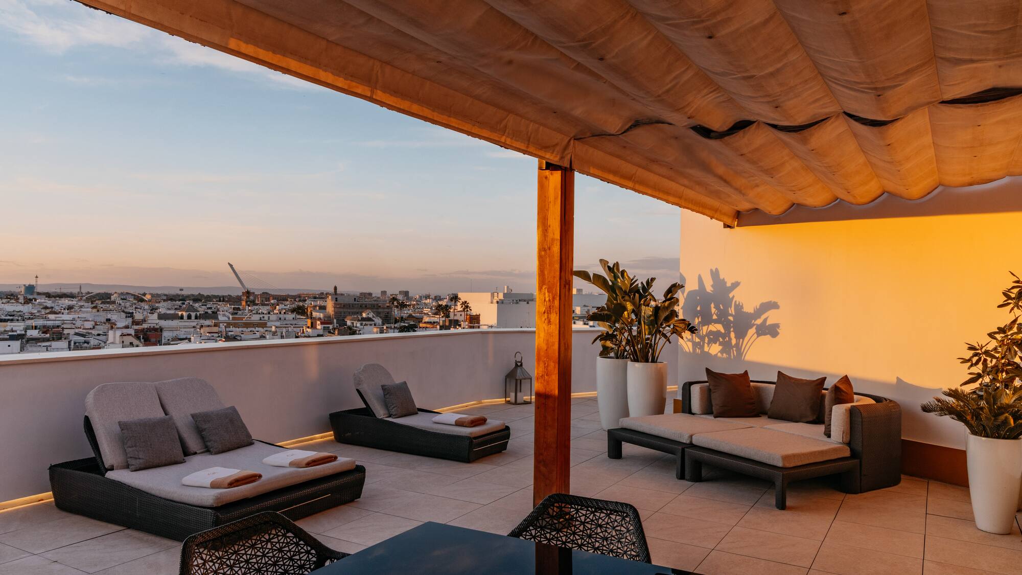 a patio with chairs and a table on a rooftop