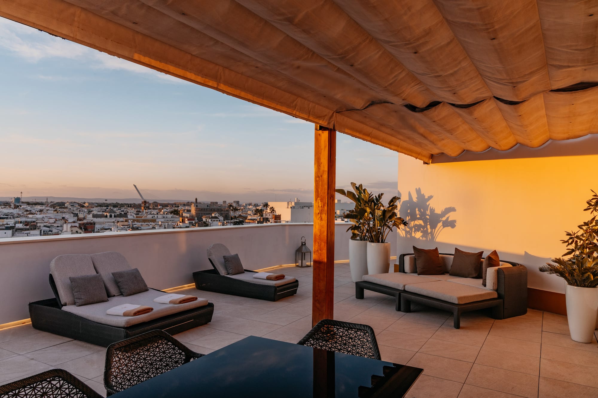 a patio with chairs and a table on a rooftop