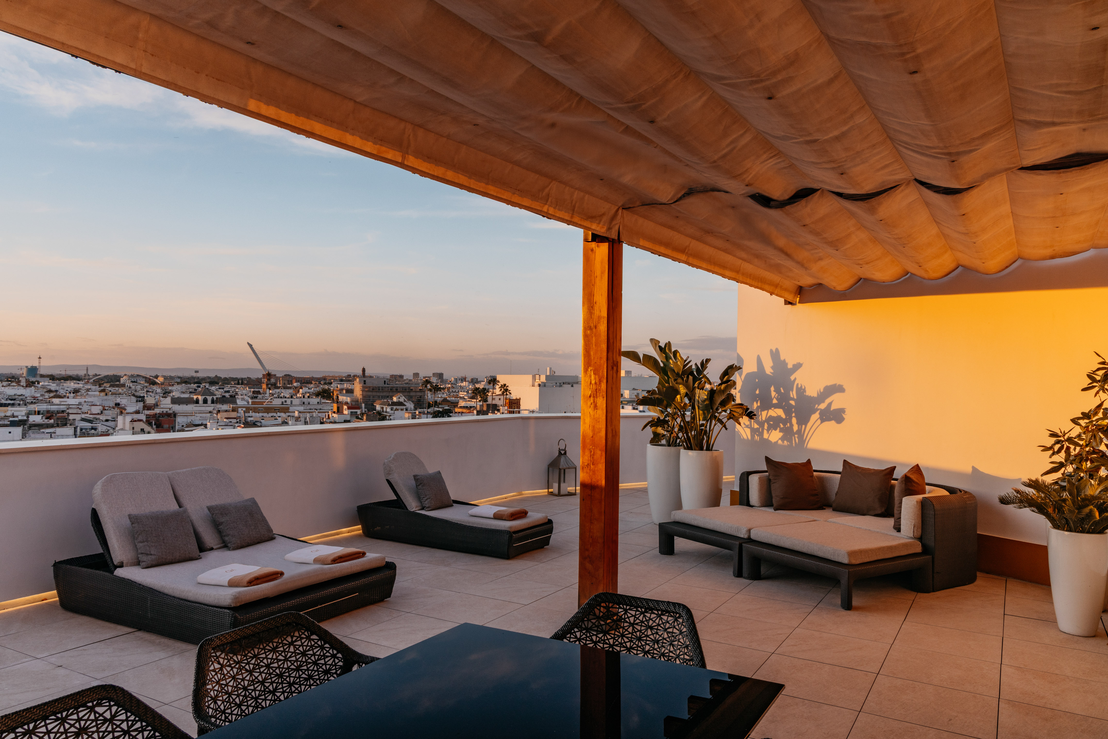a patio with chairs and a table on a rooftop