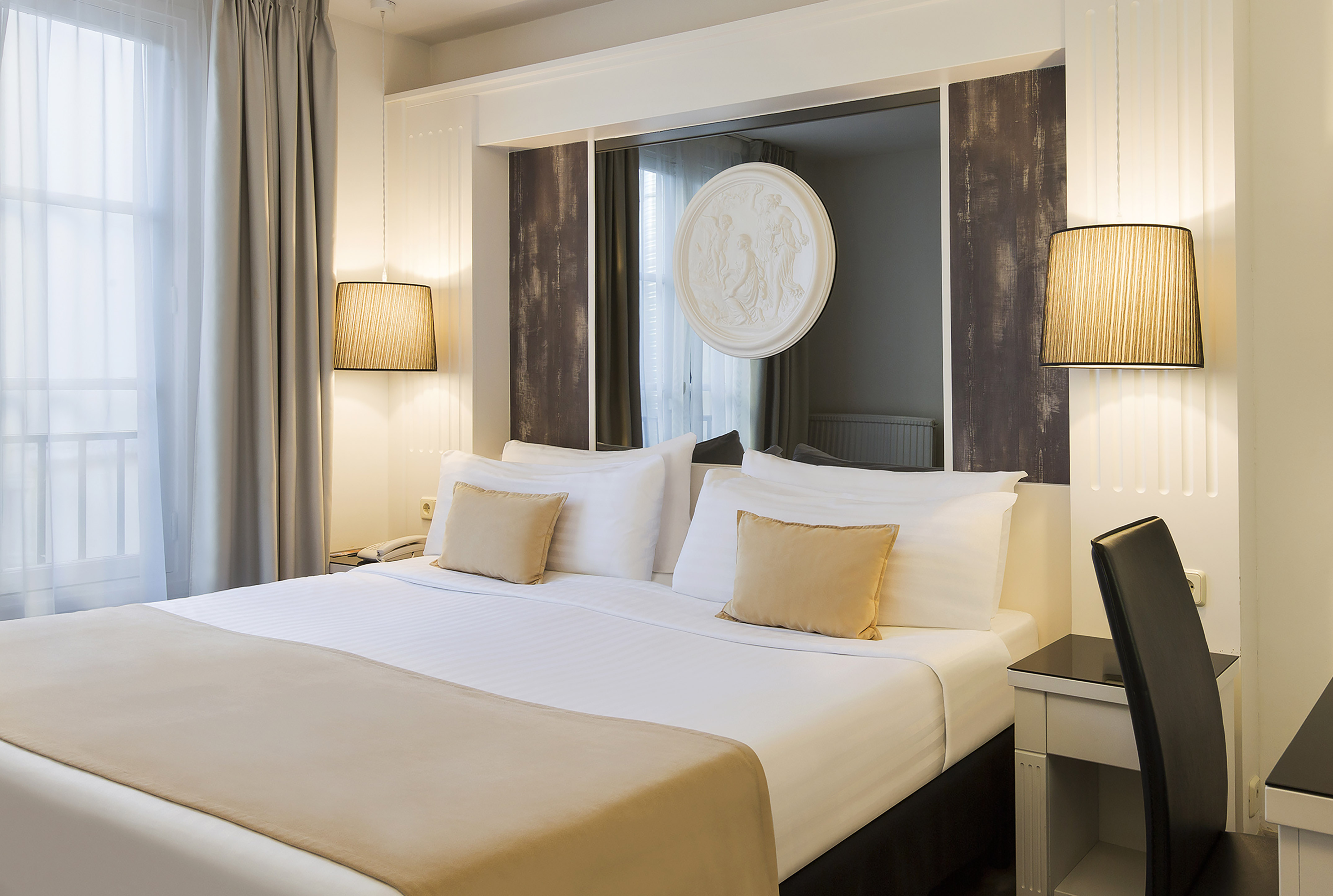Luxurious hotel room with pristine white bed, ambient lighting, and mirror art.