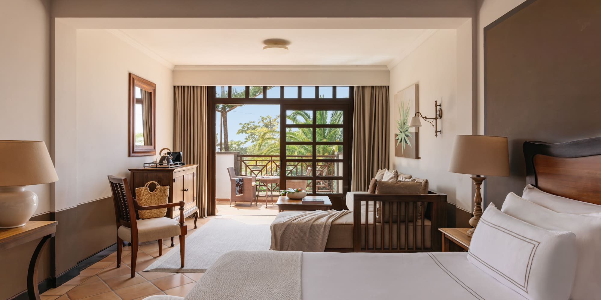 Tropical resort bedroom with private balcony and lush palm views.