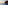 Sailboat cruising along dramatic ocean cliffs at sunset