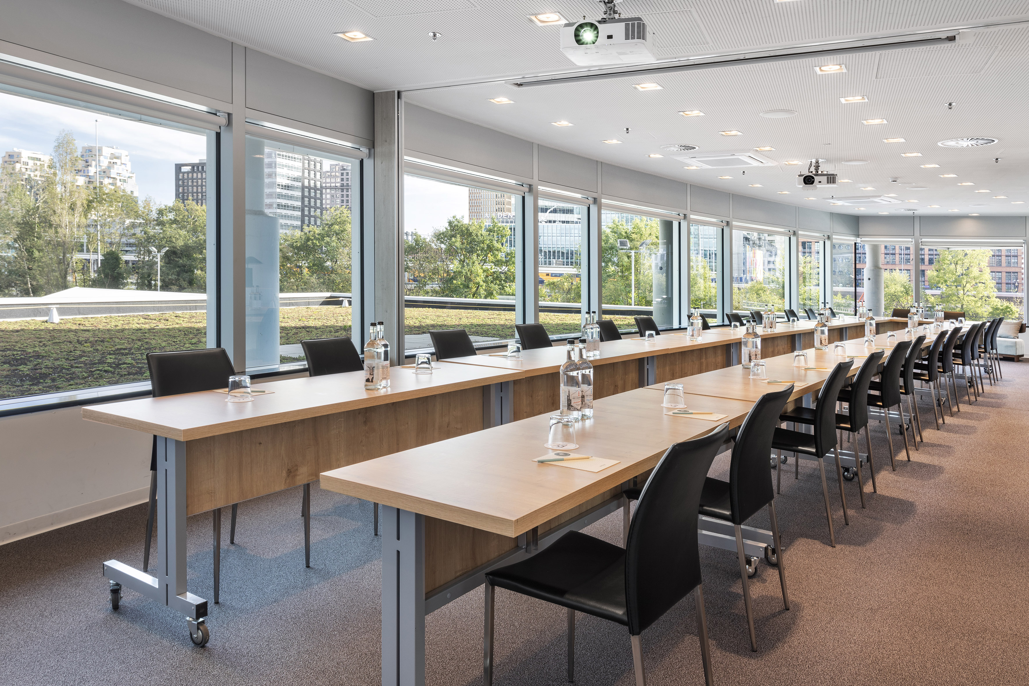 Modern conference room with city views, long tables, and natural light.