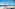Yoga on beach: woman in warrior pose under palm tree by ocean.
