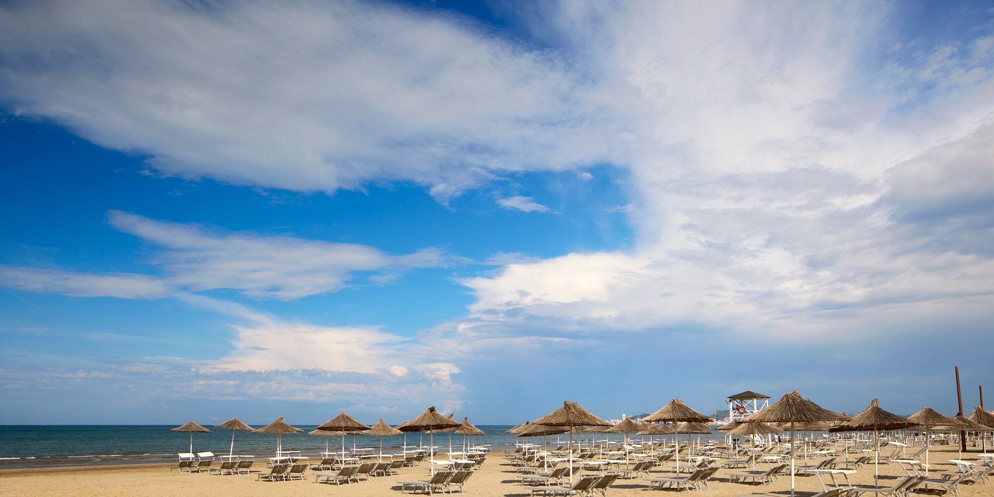a beach with umbrellas and chairs