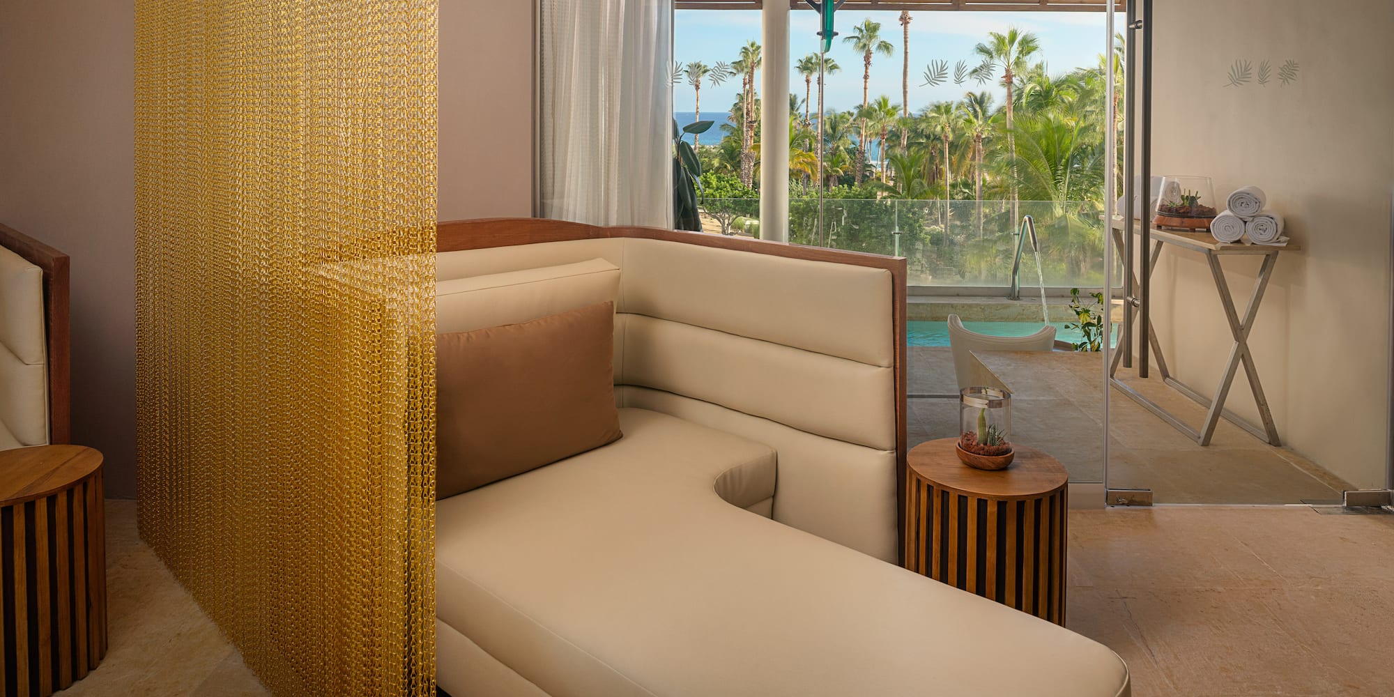 a couch in a room with a pool and palm trees