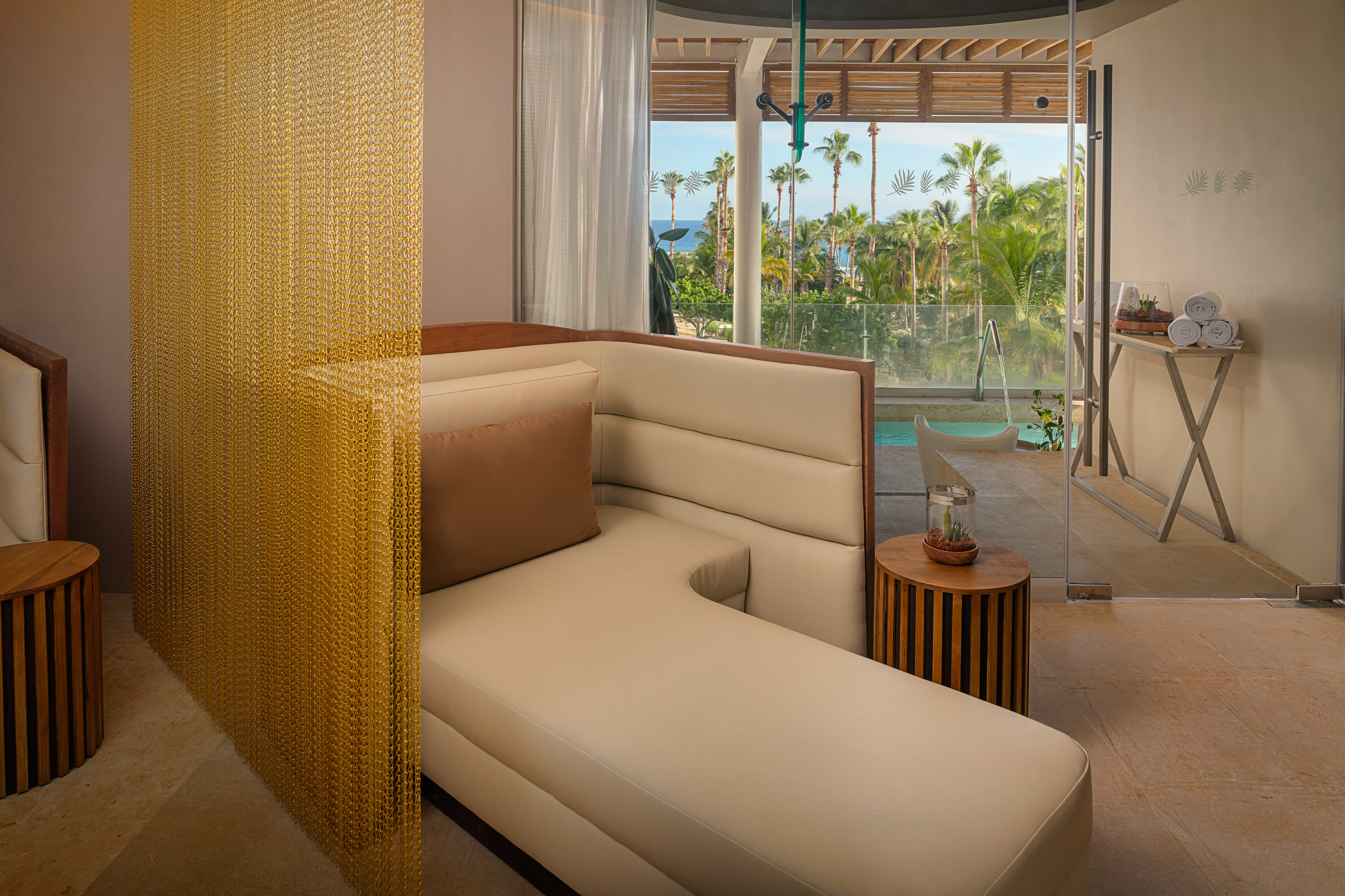 a couch in a room with a pool and palm trees