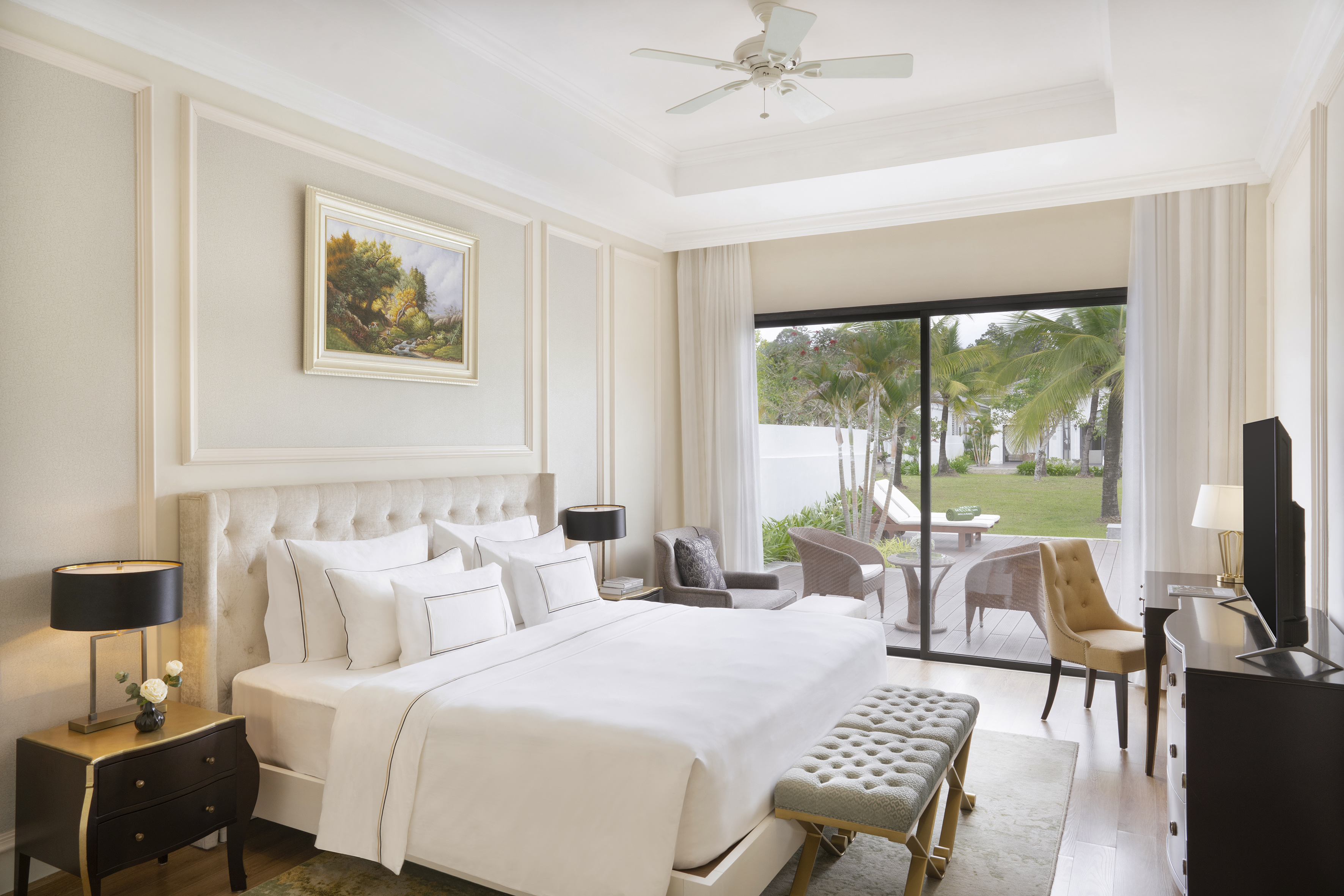 Elegant luxury hotel bedroom with king bed and tropical garden view.