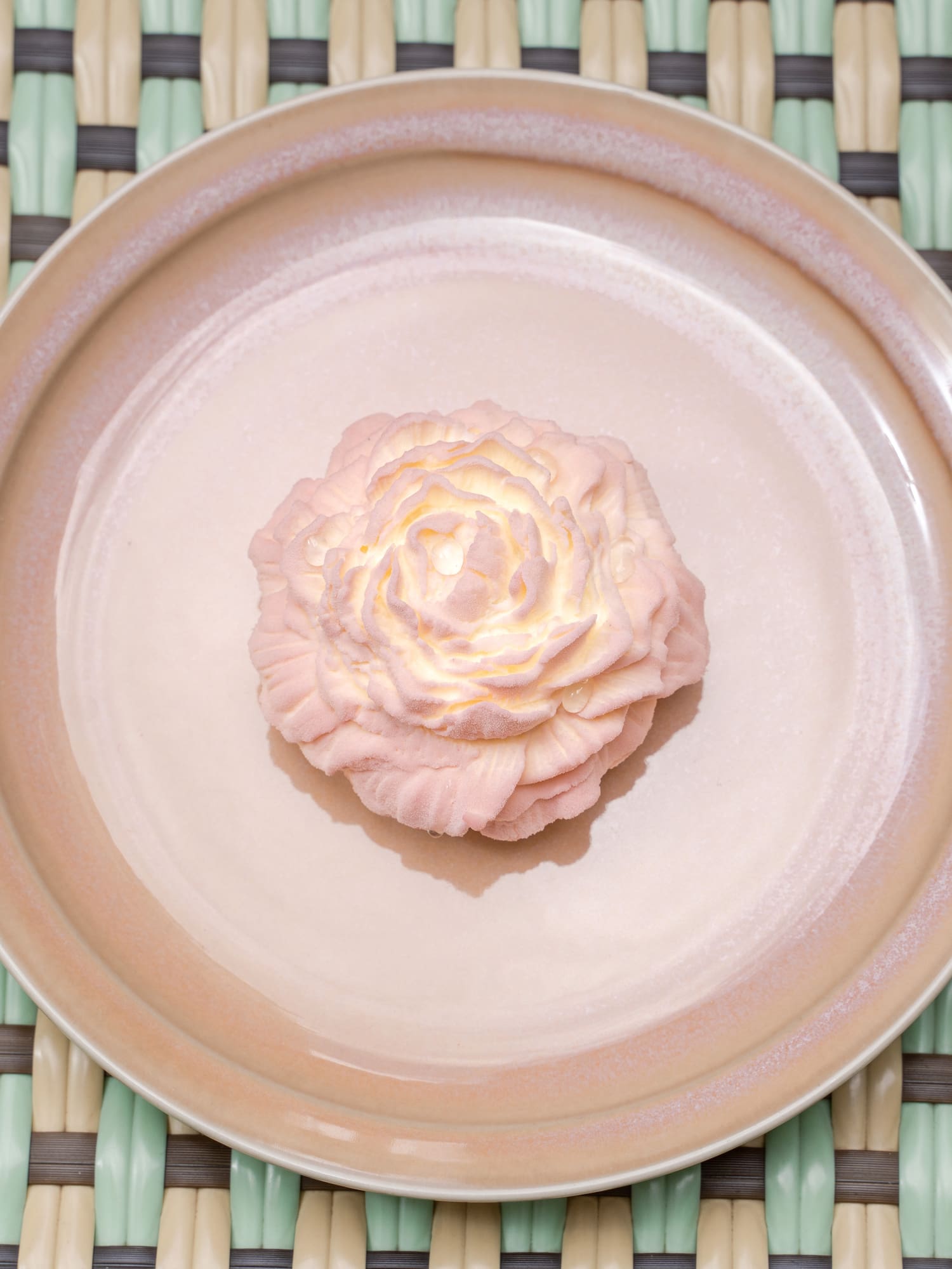 a pink flower on a plate