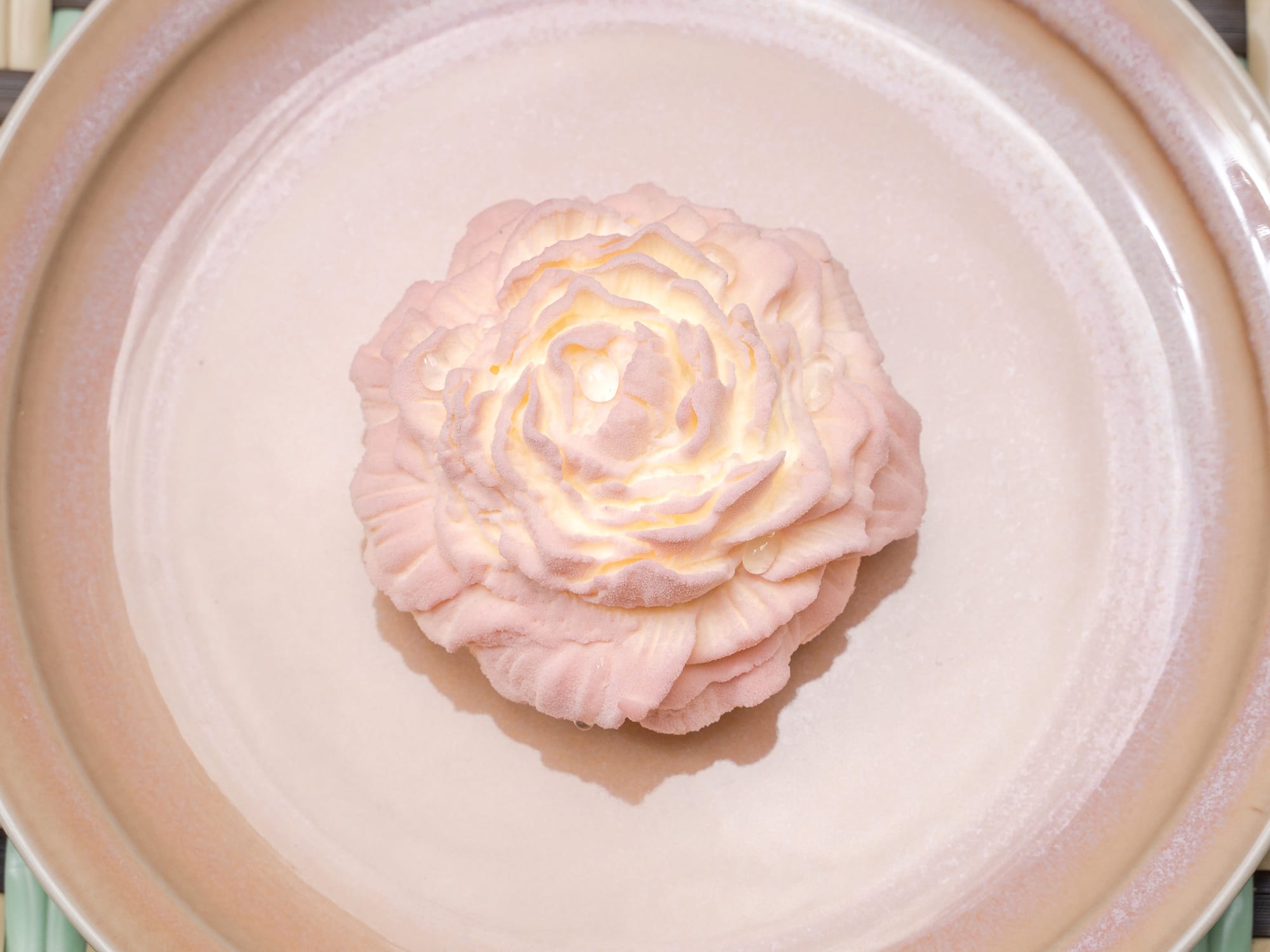a pink flower on a plate