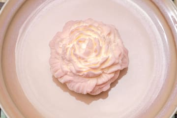 a pink flower on a plate