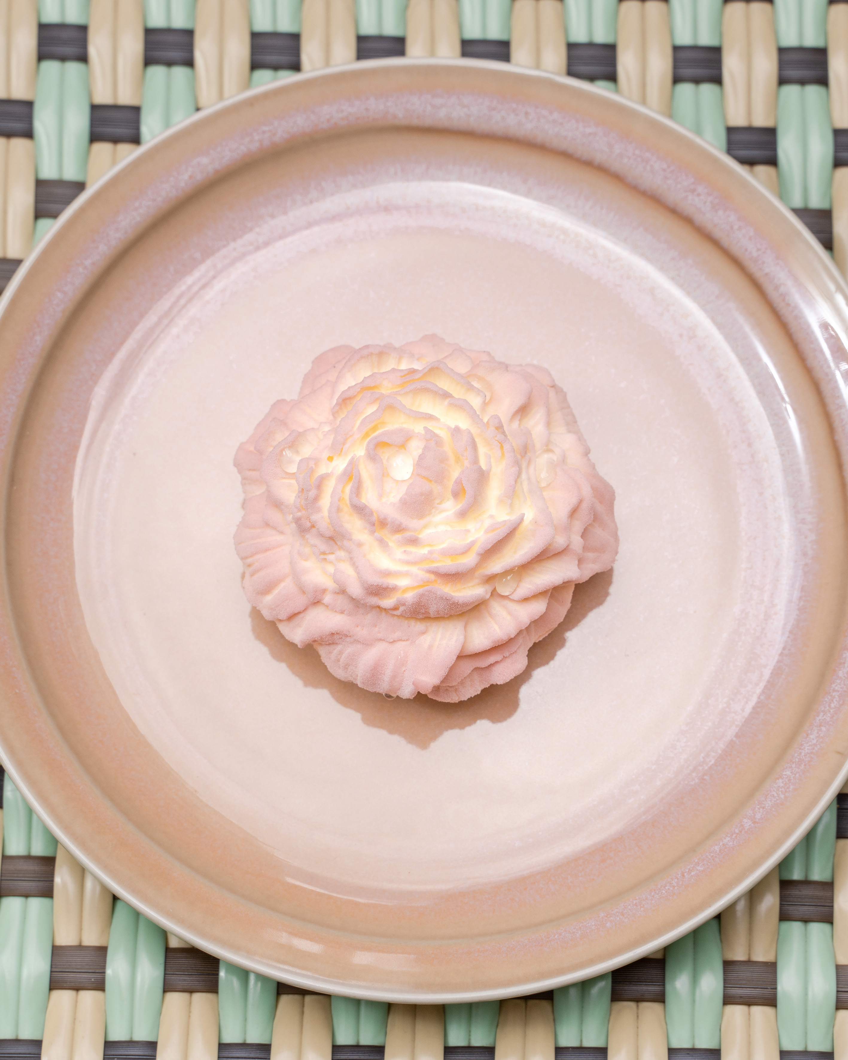 a pink flower on a plate