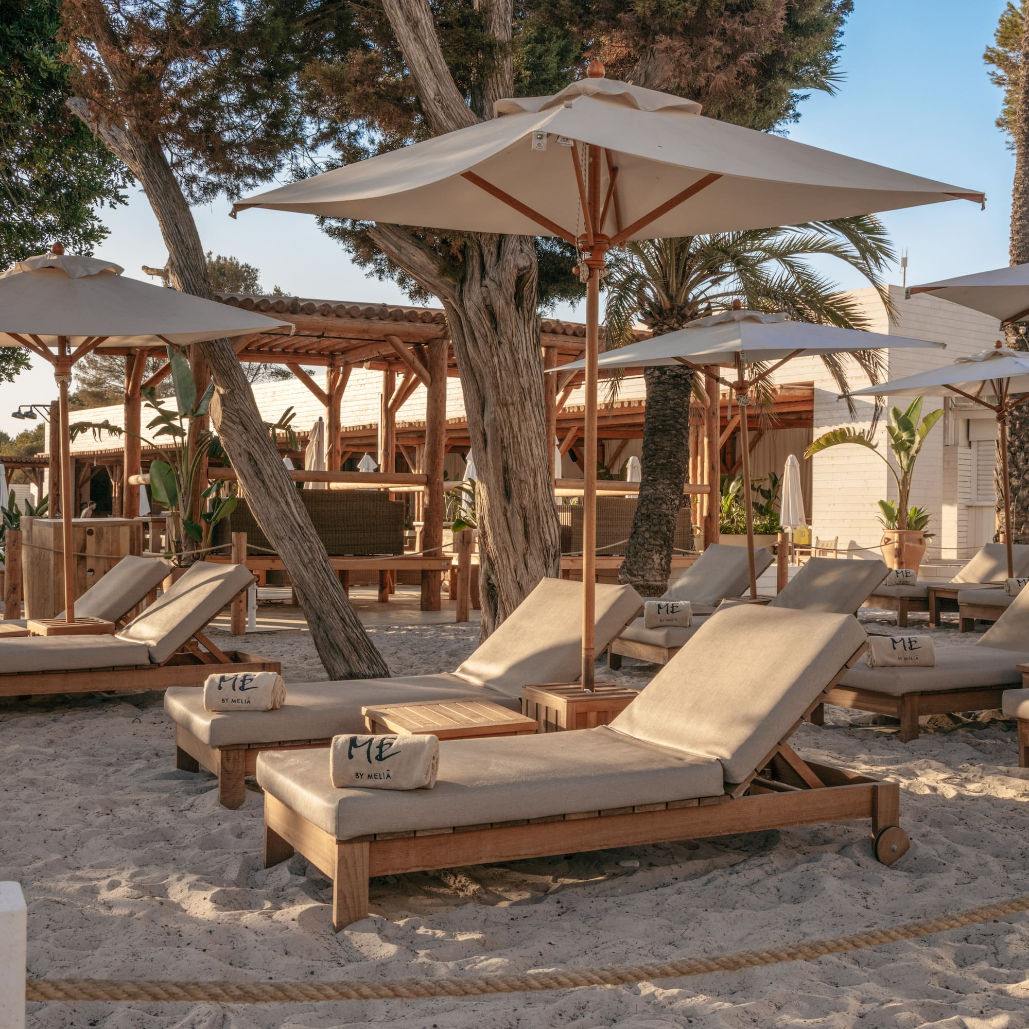 a group of lounge chairs and umbrellas on a beach