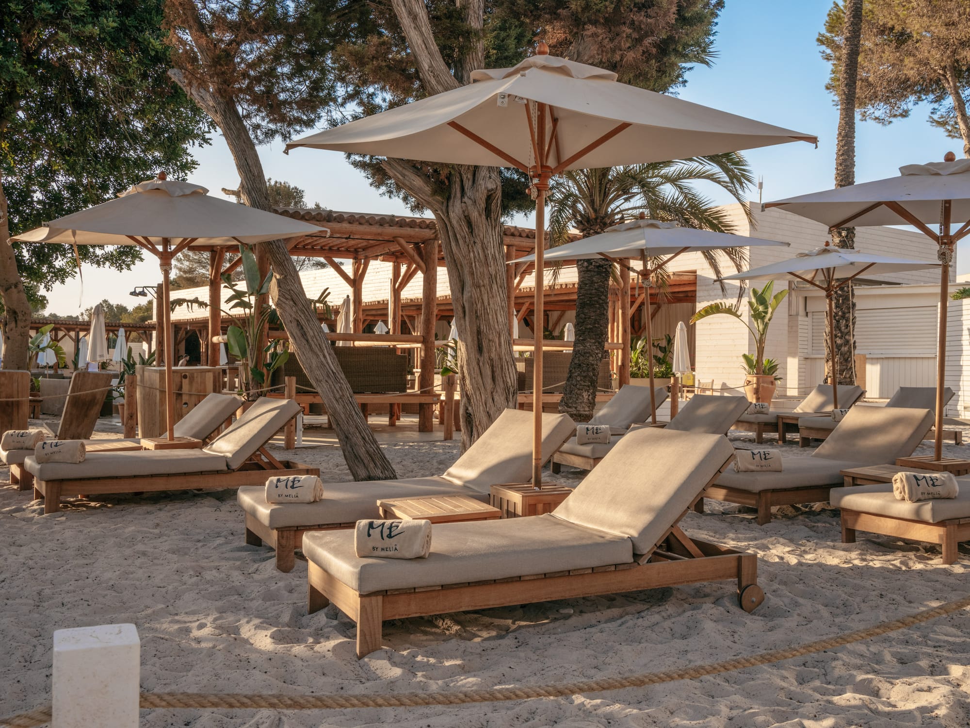 a group of lounge chairs and umbrellas on a beach