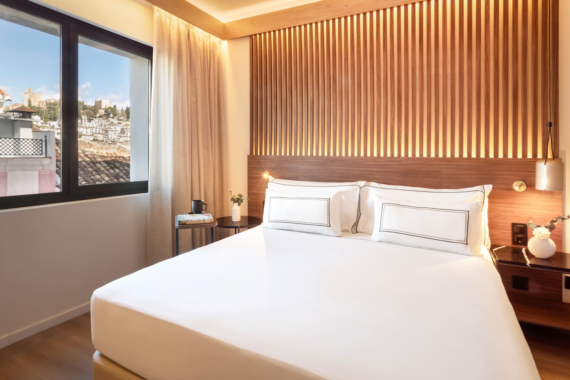 a bed with white sheets and a window