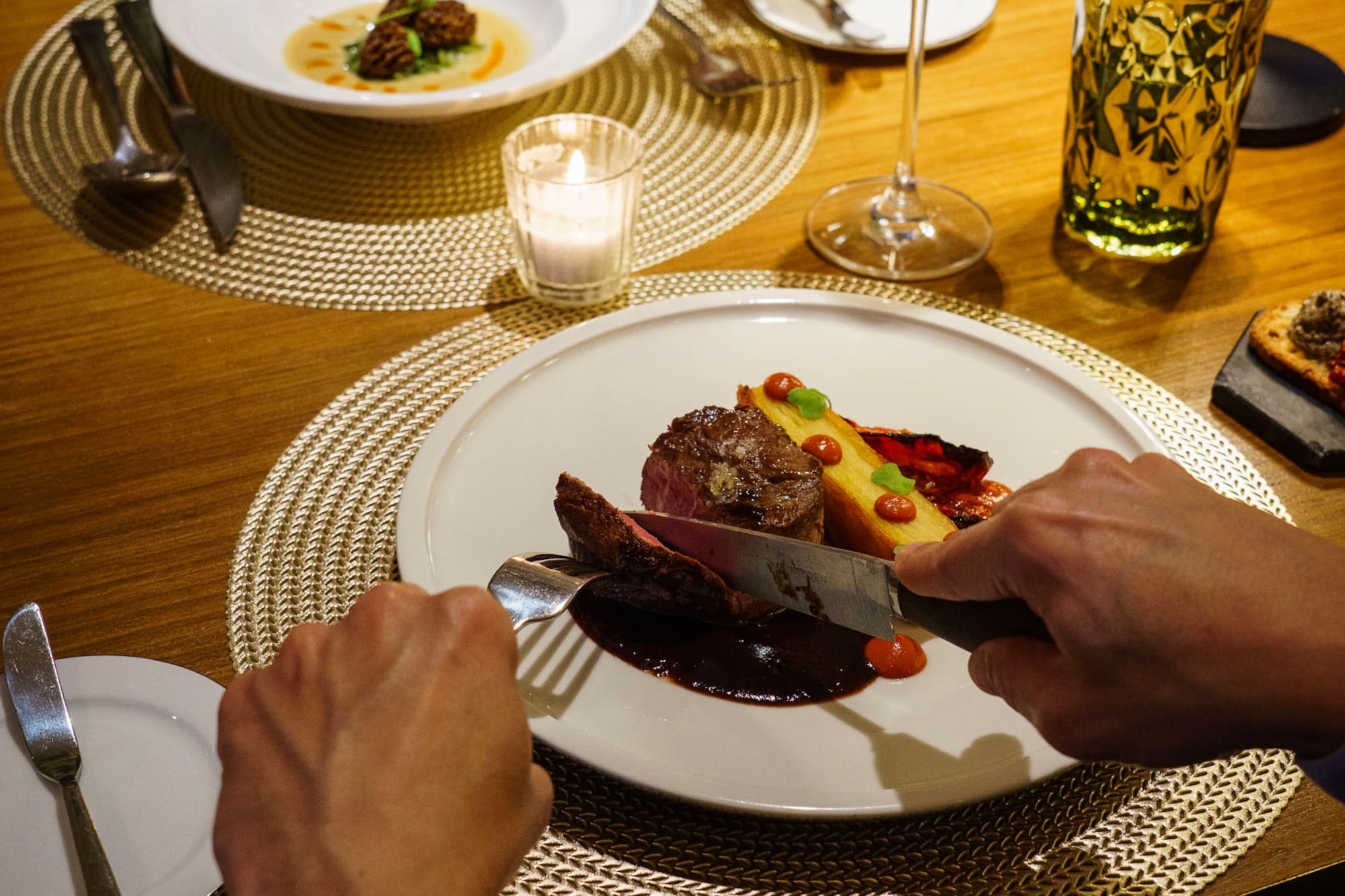 a person cutting food on a plate