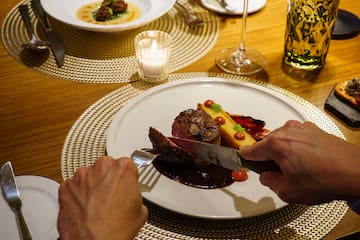 a person cutting food on a plate
