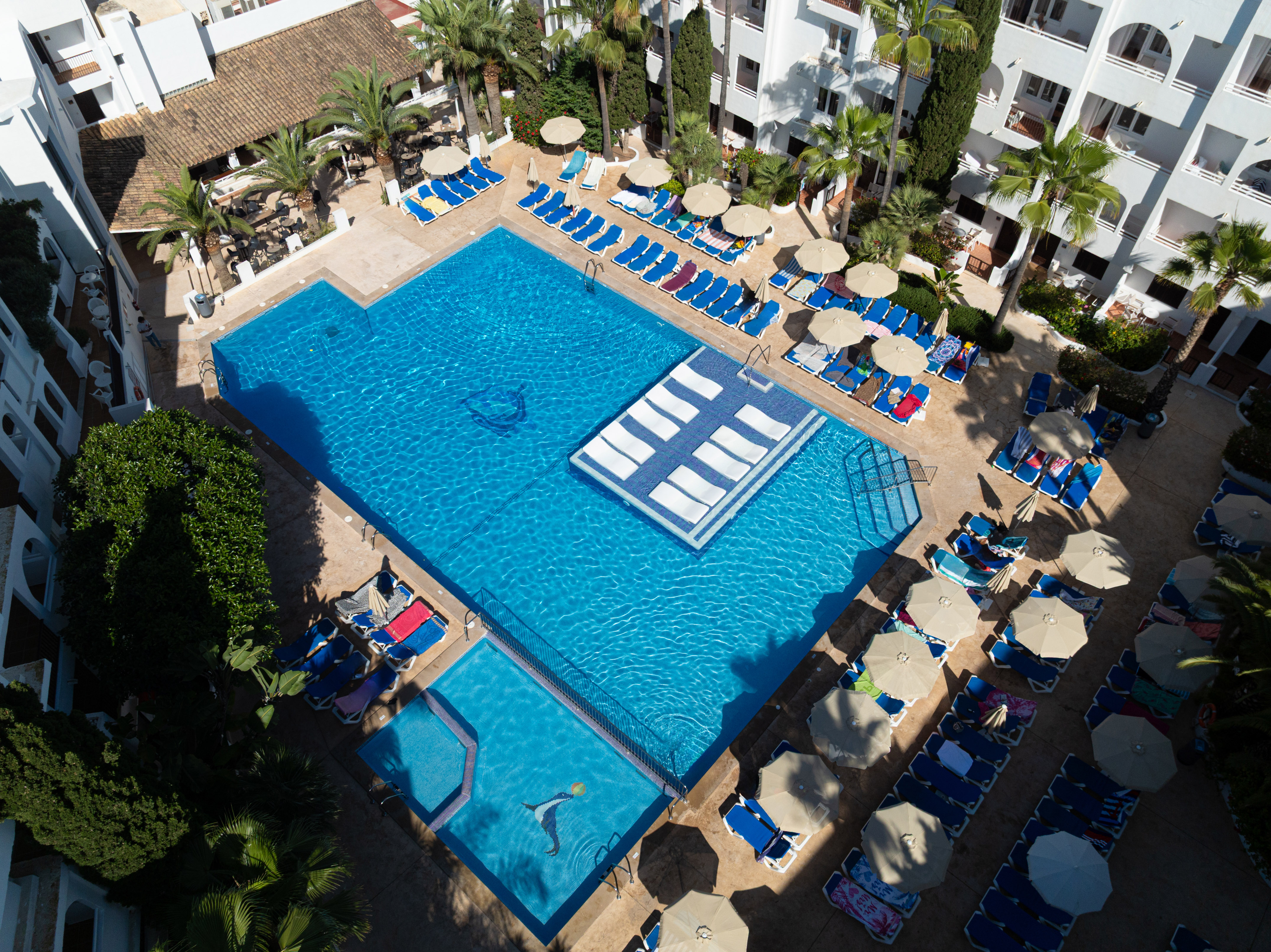 a swimming pool with lounge chairs and umbrellas