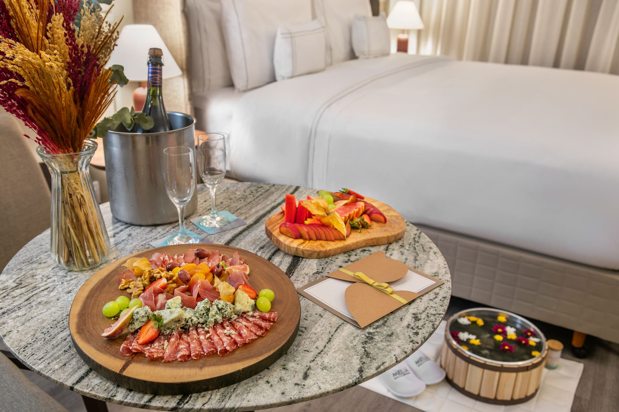 Meliá hotel room: charcuterie board, fruit platter, champagne, and foot spa.