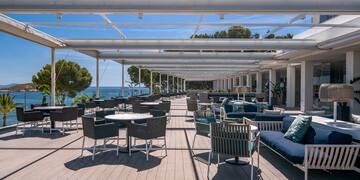 a patio with chairs and tables on a deck