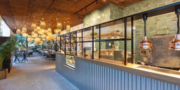 a restaurant with a glass wall and a ceiling