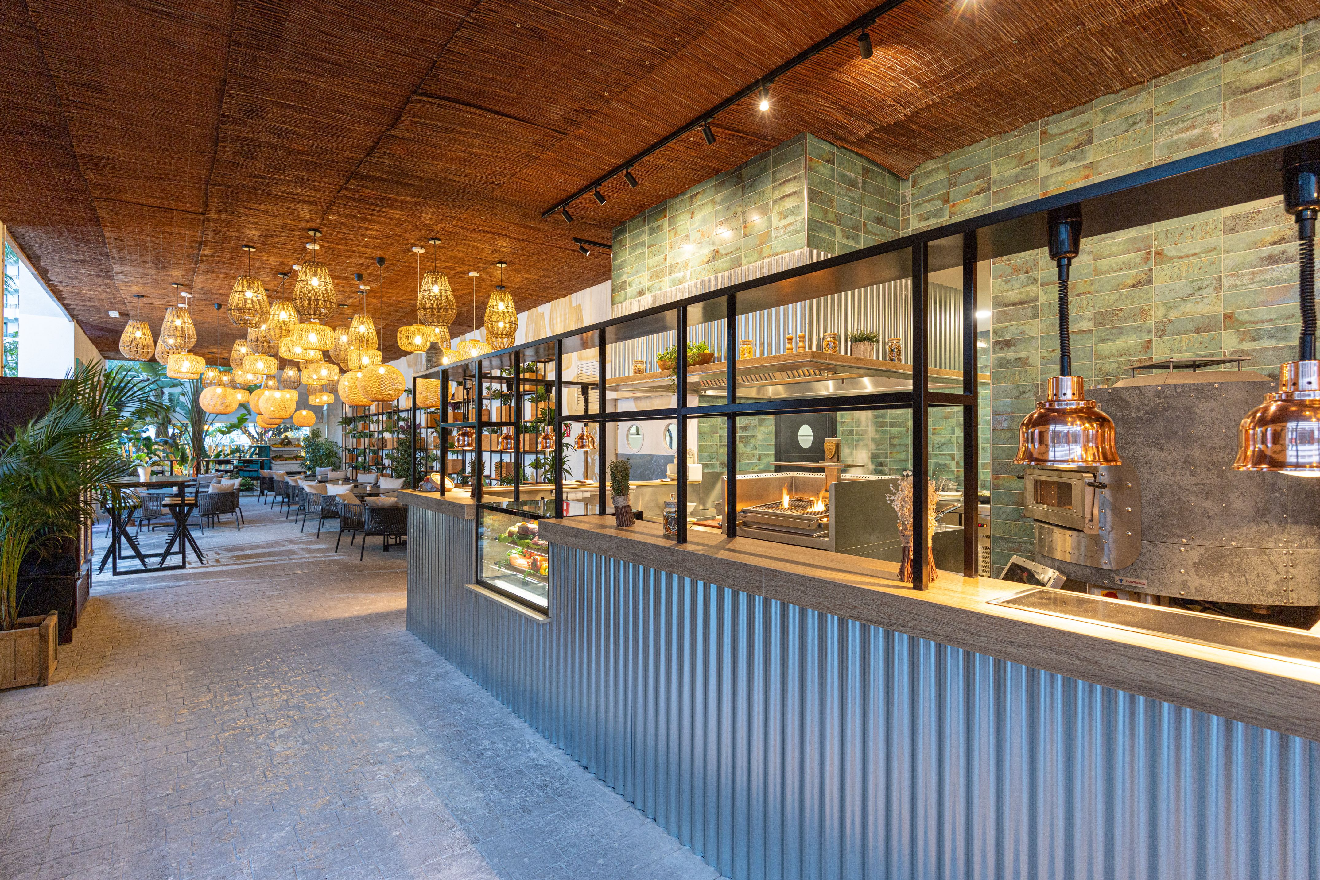 Modern restaurant interior, open kitchen bar, rattan lights, bamboo ceiling.