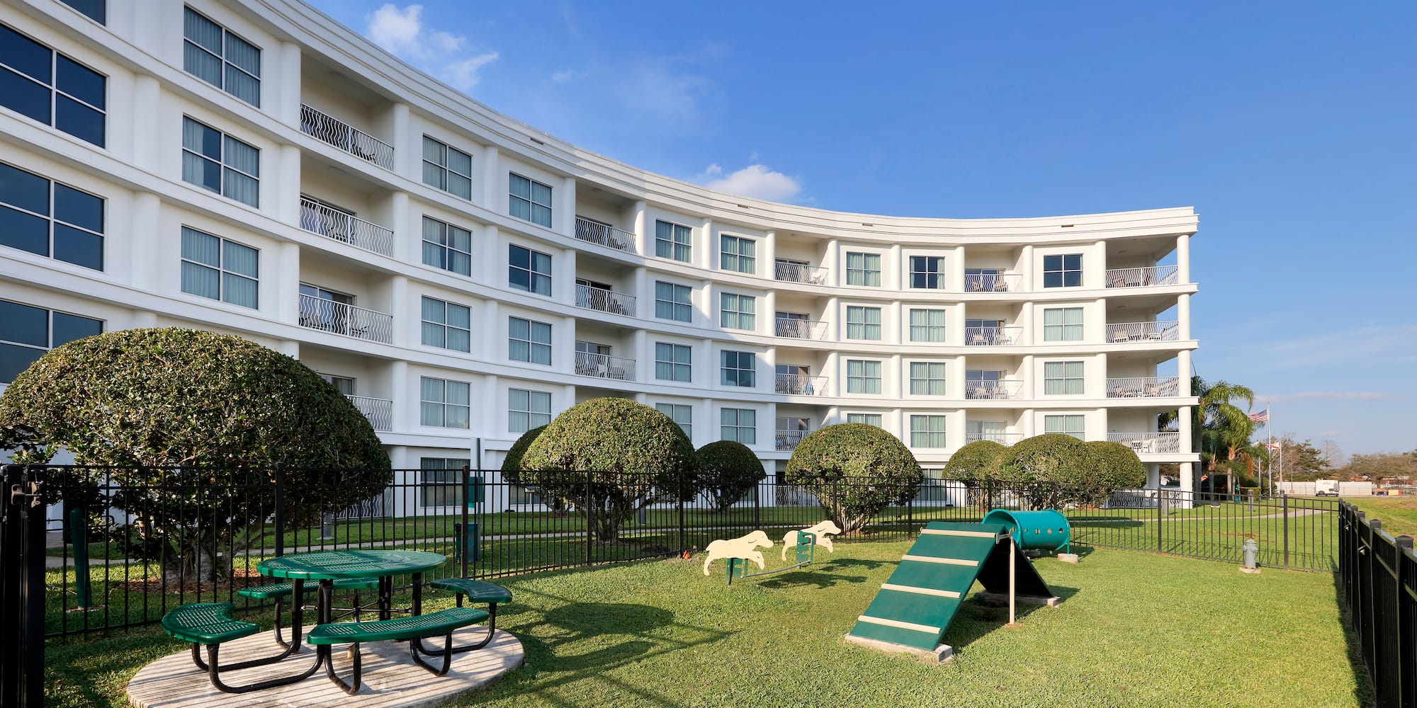 a white building with a playground and trees