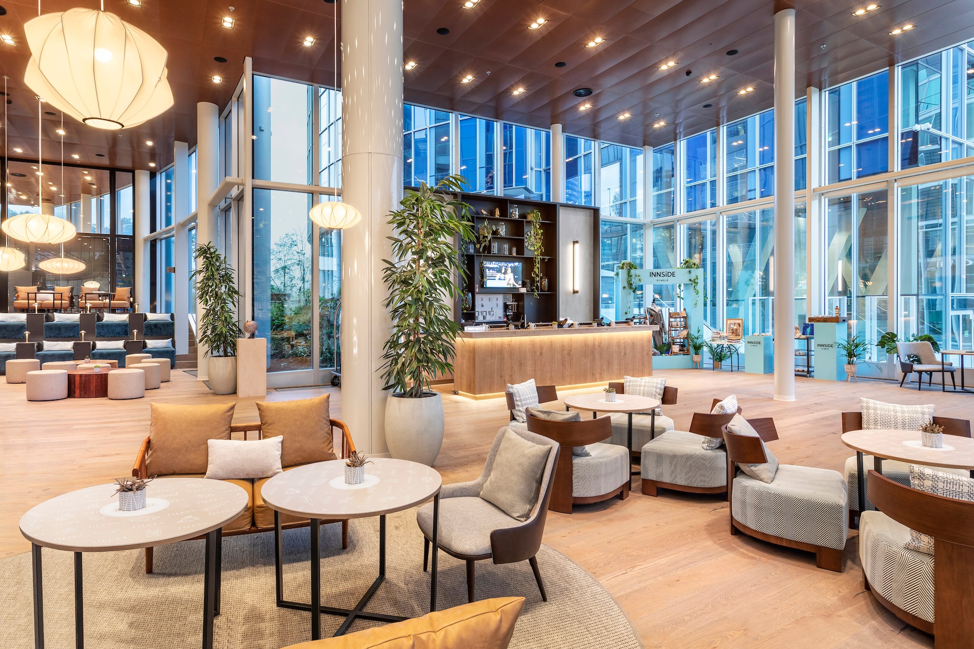 Modern hotel lobby lounge with stylish seating, bar, and natural light.