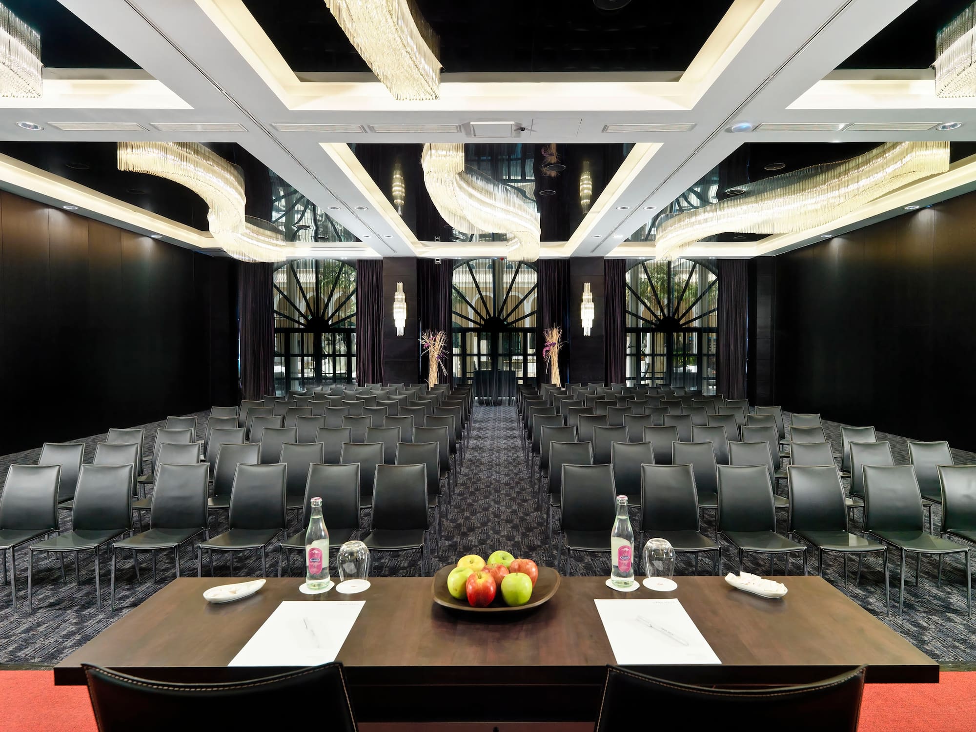 a room with chairs and a table with fruit on it