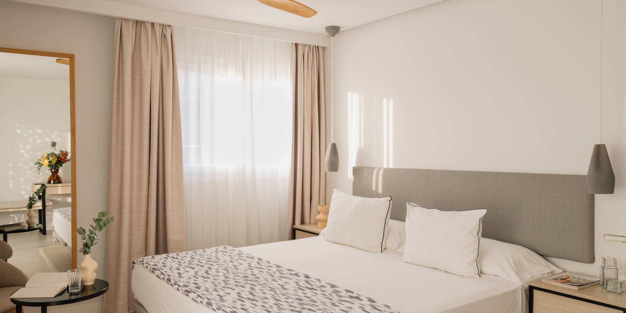 a bed with a fan in the corner of the room