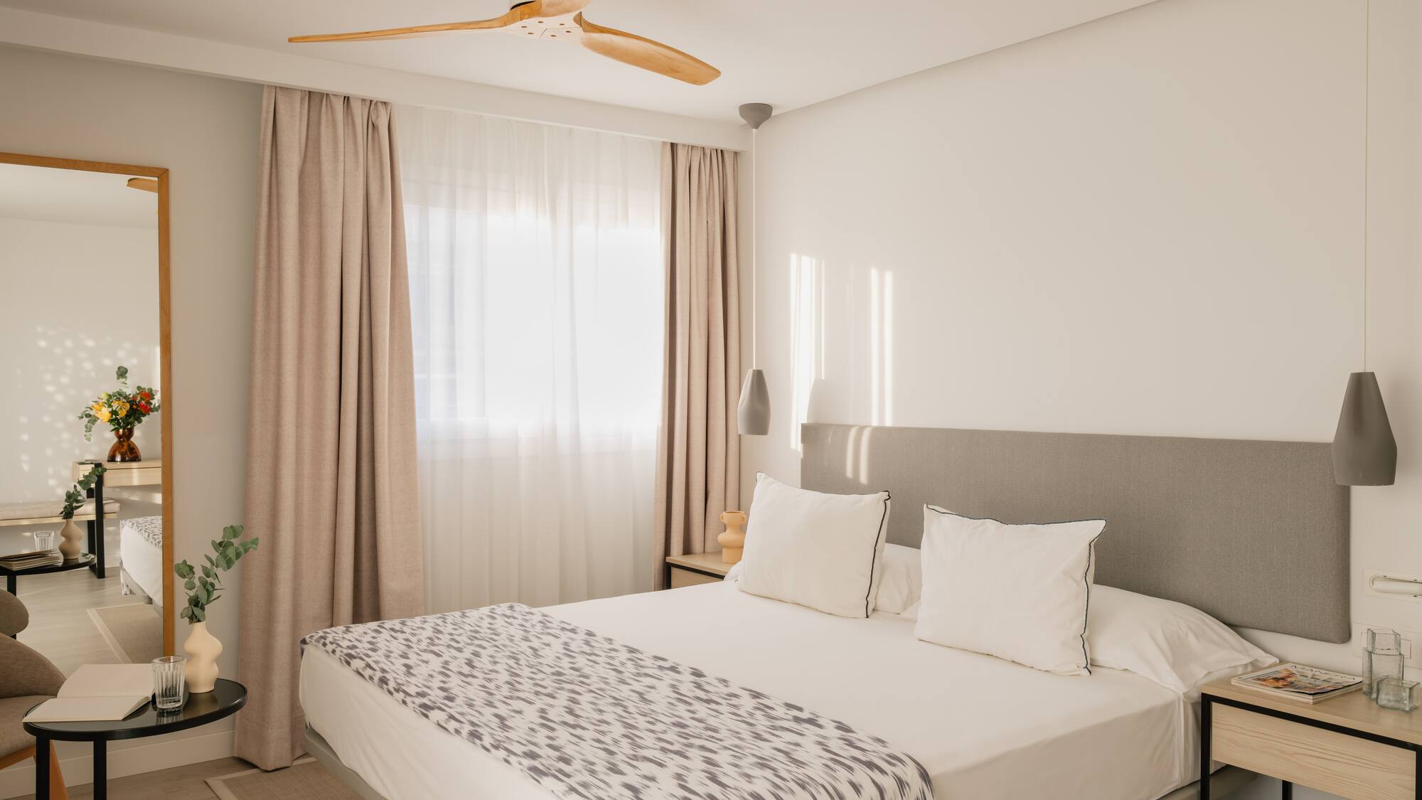 a bed with a fan in the corner of the room