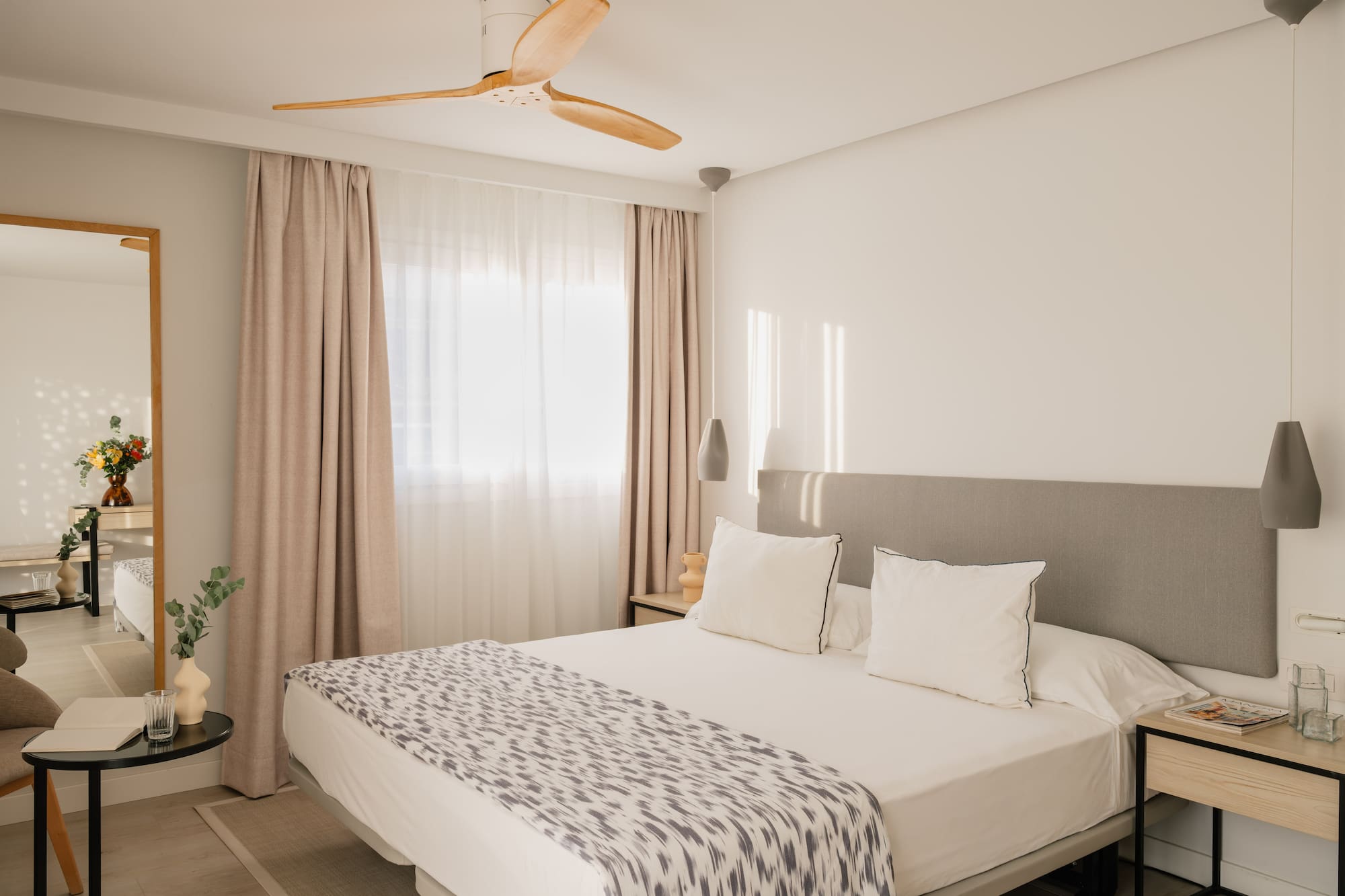 a bed with a fan in the corner of the room
