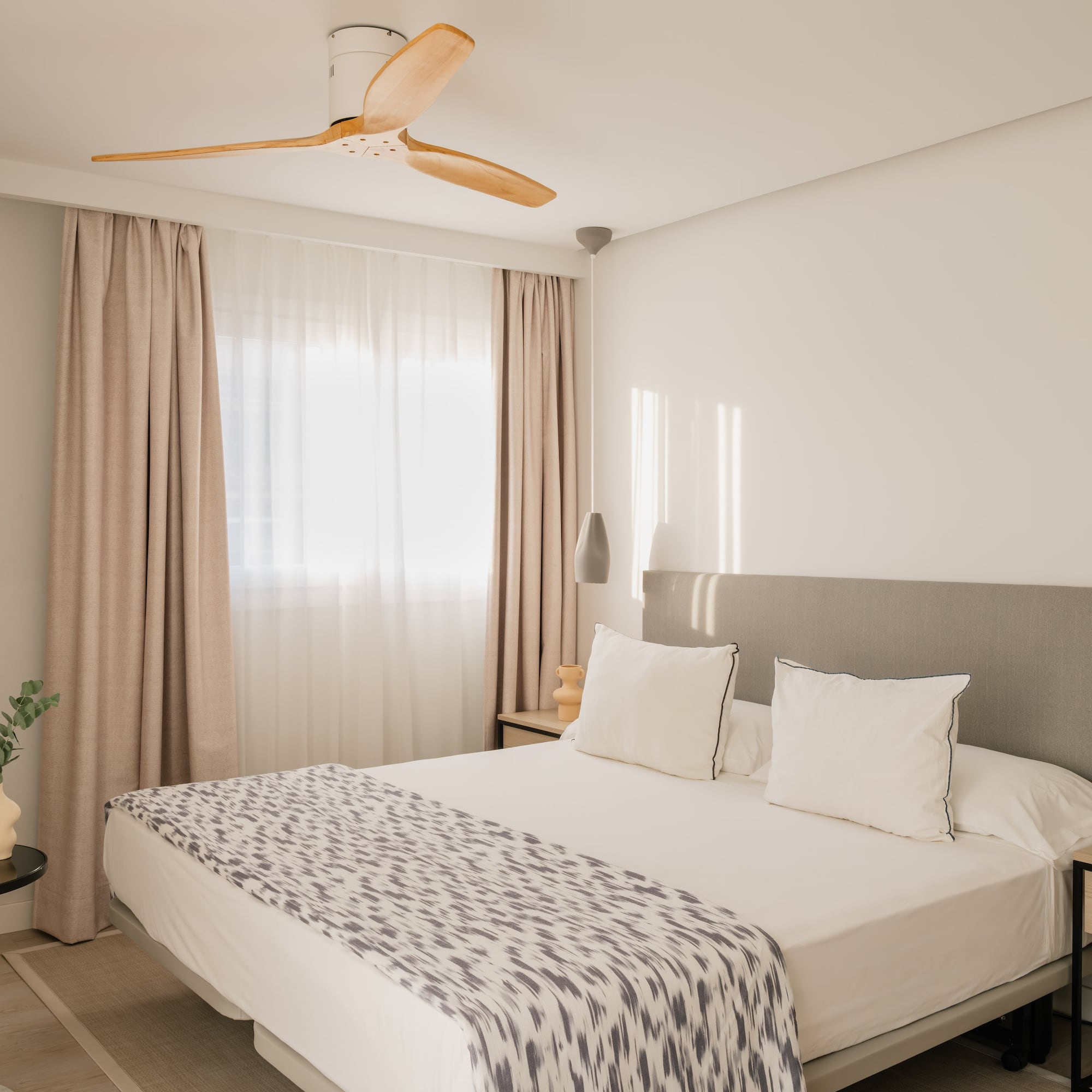 a bed with a fan in the corner of the room