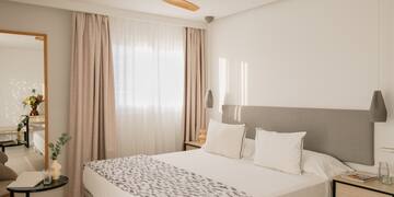 a bed with a fan in the corner of the room