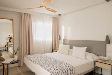 a bed with a fan in the corner of the room