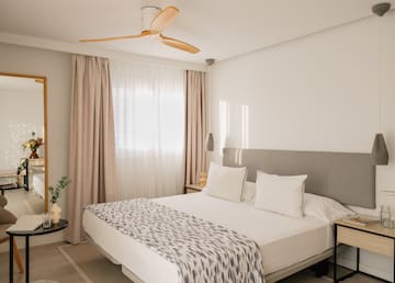 a bed with a fan in the corner of the room