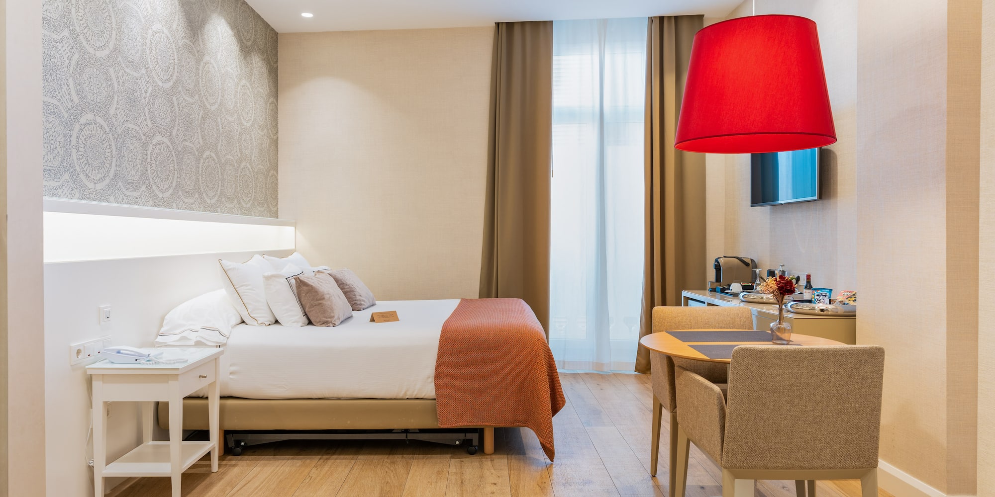 a room with a bed and a table and chairs