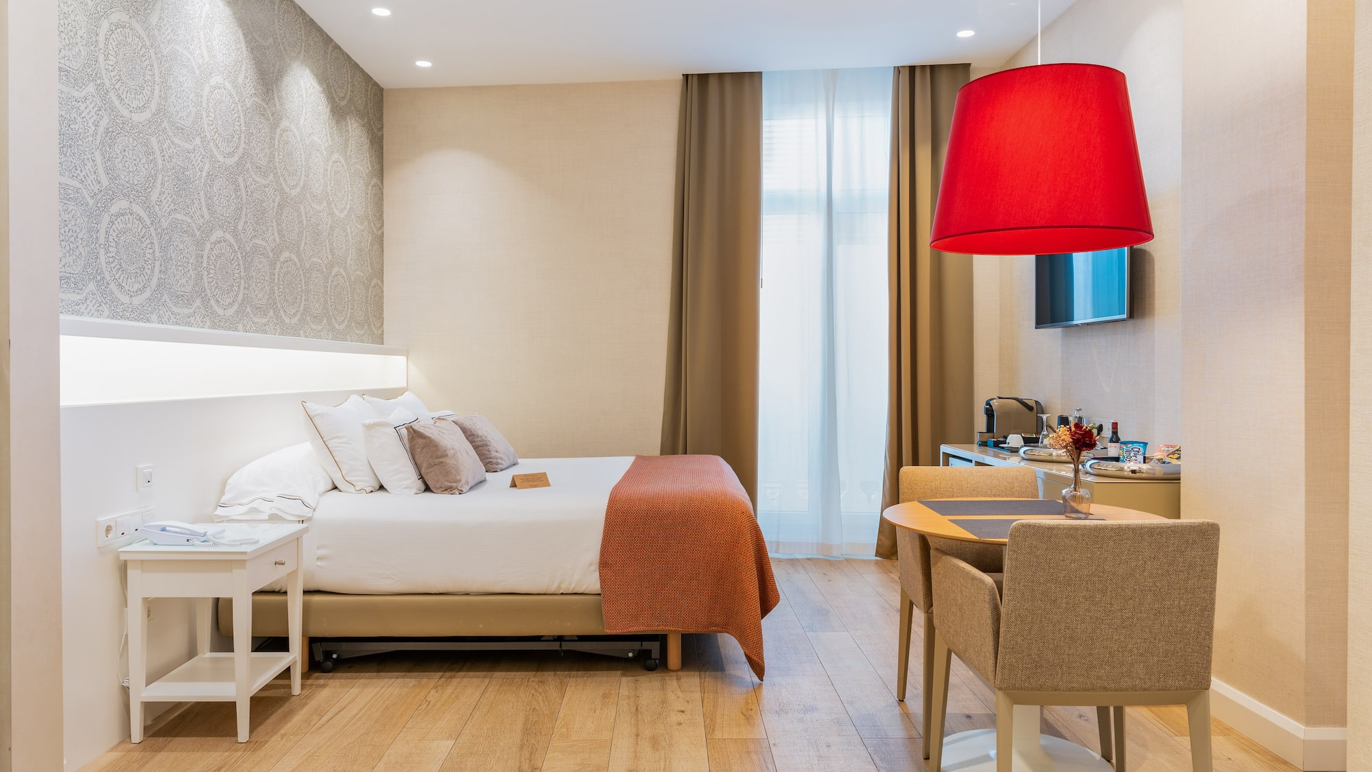 a room with a bed and a table and chairs