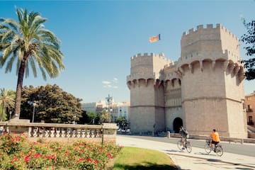 a couple of people riding bikes in front of a castle