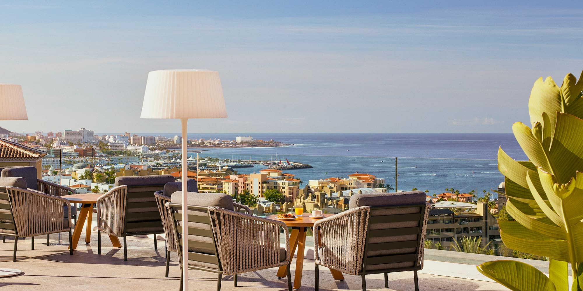 a table and chairs on a rooftop overlooking a city