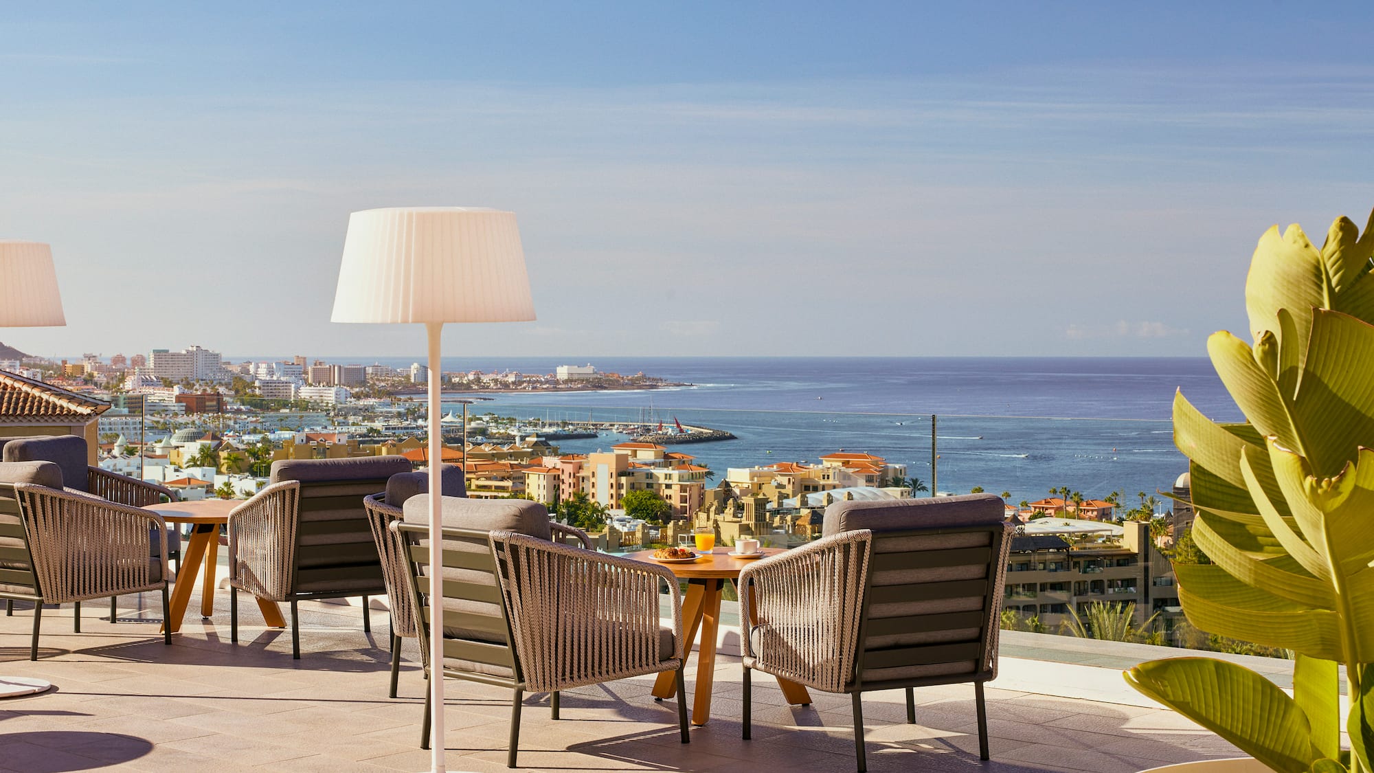 a table and chairs on a rooftop overlooking a city