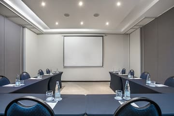 a room with tables and chairs and a projector screen
