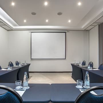 a room with tables and chairs and a projector screen