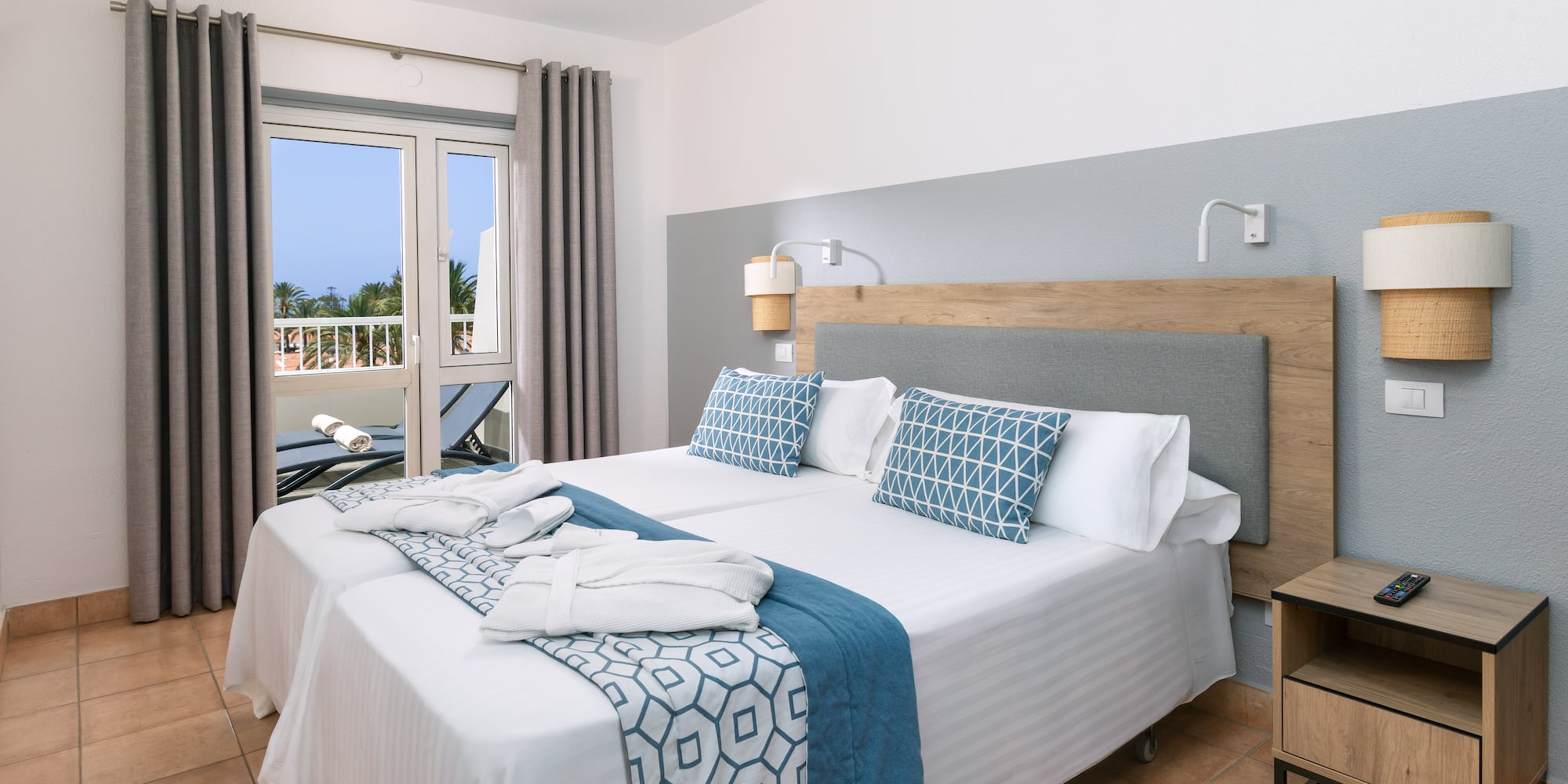 a bed with white and blue blankets and pillows