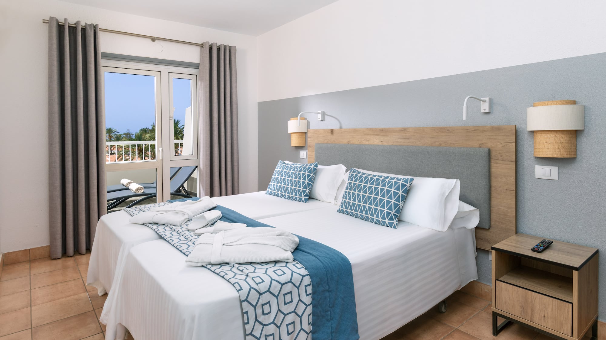 a bed with white and blue blankets and pillows