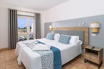 a bed with white and blue blankets and pillows